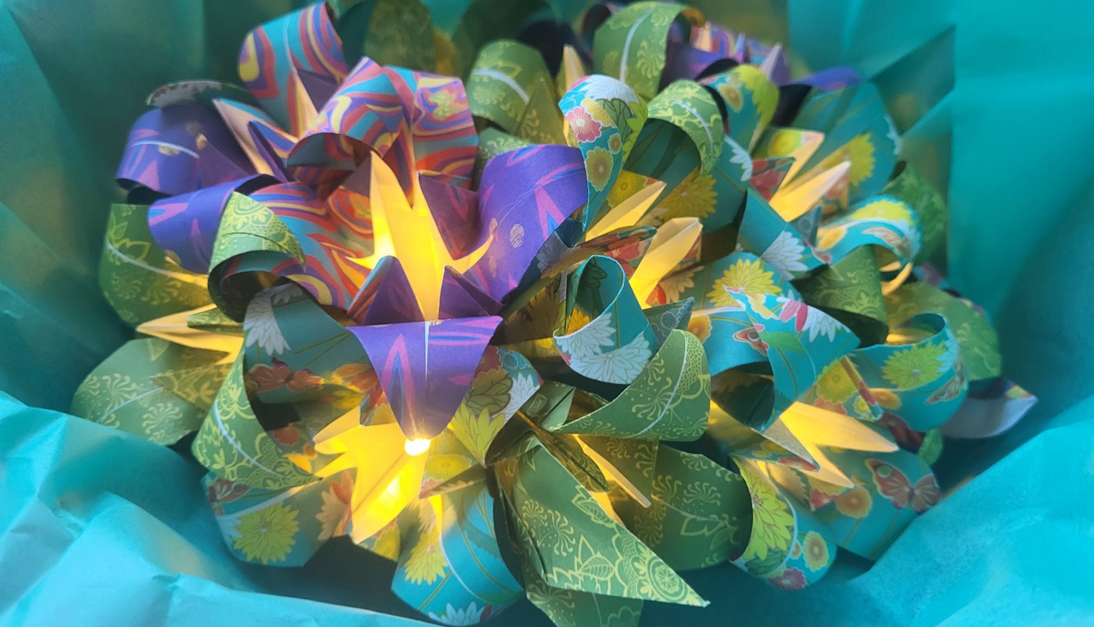 Gros plan sur une guirlande florale lumineuse dans son écrin turquoise