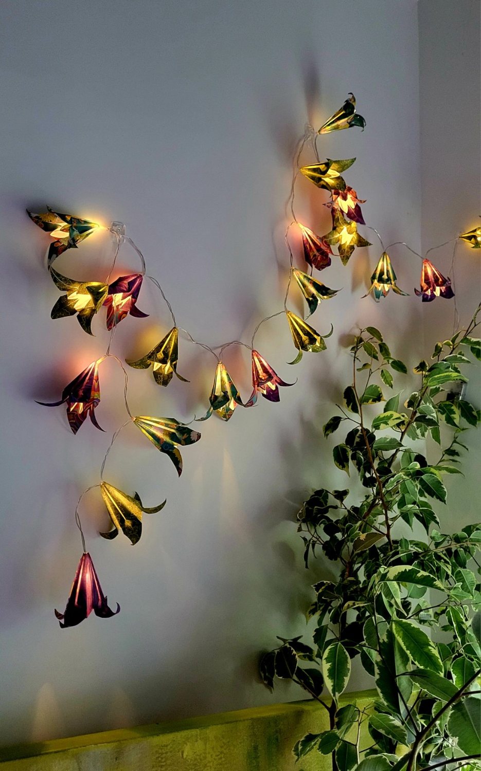 Guirlande lumineuse florale en papier japonais parmi les plantes