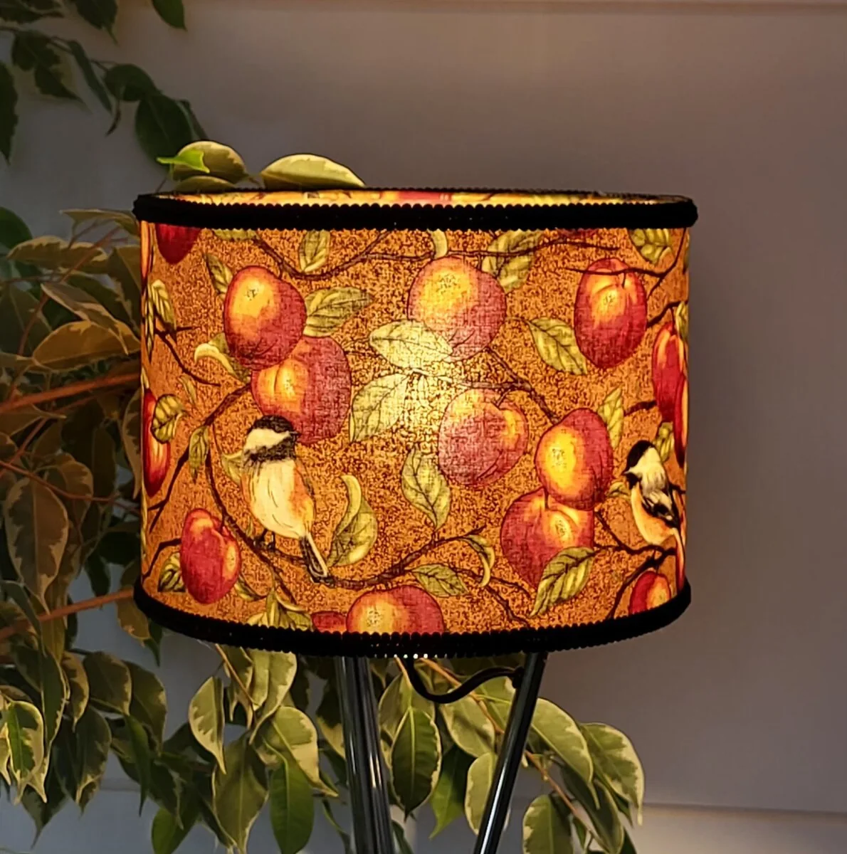 Abat-jour artisanal aux pommes et à l’oiseau, lumière allumée